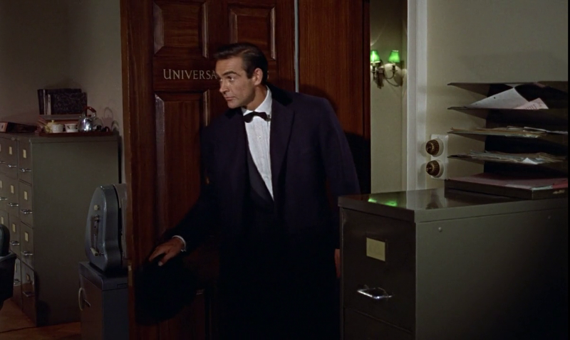 After opening the door to M's office, you can see the door has the import/export company's name prominently displayed on its front