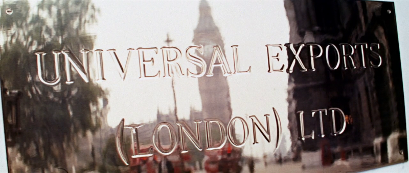 A golden UnivEx sign is prominently displayed as the setting for the next scene, MI6's office (Note: Director Peter Hunt's reflection makes a cameo in the image)